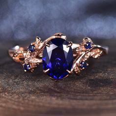 a ring with a blue stone surrounded by leaves