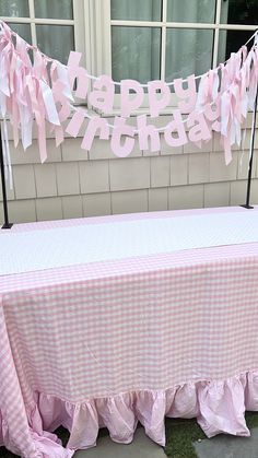 a table with pink gingham cloths on it in front of a window