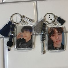 two key chains hanging from the side of a refrigerator freezer with pictures on them