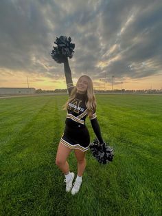 a cheerleader standing in the middle of a field