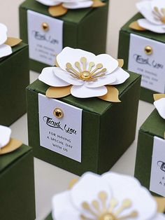 several green boxes with white and gold flowers on them