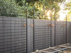 the fence is made of wood and metal, along with some concrete blocks in front of it