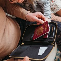 a woman sitting on the floor holding a wallet and passport