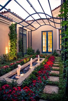 an outdoor garden with flowers and plants in the center, surrounded by a pergolated roof