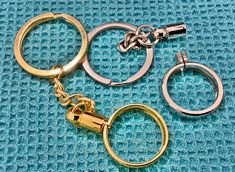 three different types of metal keychains on a blue surface with one open and the other closed