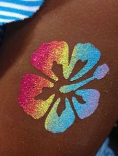 a person with a flower painted on their arm and the colors are multicolored