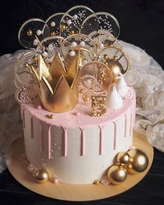 a pink and white cake with gold decorations