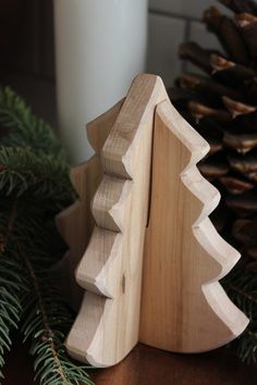 a small wooden christmas tree next to a candle