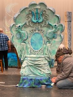 a man kneeling down next to a statue