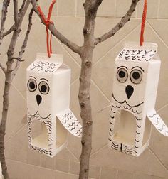 two owls made out of toilet paper hanging from branches