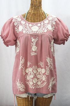 * Ornate hand embroidery and traditional puff sleeves, available here in DUSTY PINK with CREAM embroidery. * Light, gauzy and semi-sheer 100% cotton throughout; wear it billowy and flowing in the traditional bohemian style. * Dyed, distressed and embroidered entirely by hand for an authentic, retro-vintage and hippie casual vibe. * Our ornate butterfly floral embroidery patterns are a faithful tribute to the original Mexican style hippie blouses of the 1970's. * Caringly embroidered by hand, eac Dusty Light Pink, Mexican Peasant Blouse, Cream Embroidery, Pattern Outfits, Hippie Blouse, Mexican Blouse, Embroidery On Kurtis, Open Sleeves, Kurti Embroidery Design