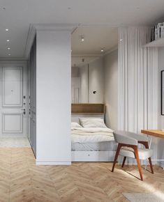 a bedroom with white walls and wood flooring next to a bed in the corner