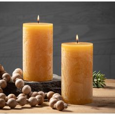 two candles are sitting next to some mushrooms