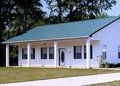 a white house with a green roof and porch