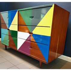 a multicolored chest of drawers sitting on the floor