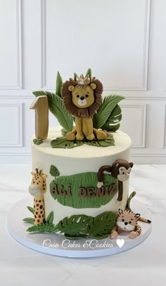 a birthday cake with a lion and giraffe on it's top tier