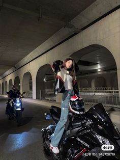 a woman standing on top of a motorcycle next to another motorcycle in a parking garage