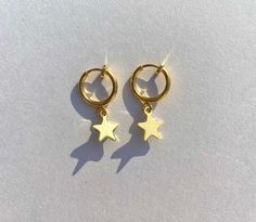 Elevate your accessories with our dazzling gold star clip-on earrings, perfect for adding a touch of celestial charm to any outfit.  Materials: Gold stainless steel clip-on hoops Gold stainless steel star charm Gold Star-shaped Celestial Huggie Earrings, Gold Star Celestial Huggie Earrings, Gold Star Huggie Earrings In Celestial Style, Gold Star Shaped Huggie Earrings, Celestial Star-shaped Huggie Earrings With Star Charm, Celestial Star-shaped Gold Huggie Earrings, Gold Star Charm Hoop Earrings, Gold Star-shaped Metal Hoop Earrings, Everyday Gold Star Huggie Earrings