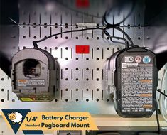 there are two batteries attached to the back of a wall mounted charger on a pegboard