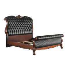 an antique style bed with black leather upholstered headboard and foot board