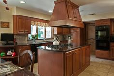 a kitchen with an oven, stove and dining room table in the middle of it