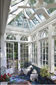 a sun room with many windows and furniture