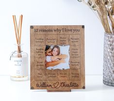 a personalized wooden frame with a couple's photo and reeds next to it