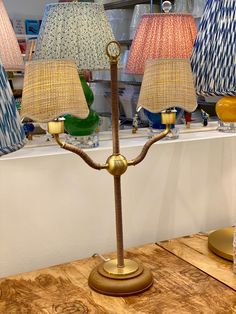 three lamps on a table in front of a window with other lamps behind them,