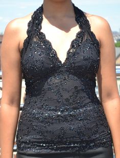 "Gorgeous sleeveless halter stretch lace waist length top in black color hand-decorated with matching color beads and sequins, very nice wear for special occasions. The neck strap is also beaded but the back part is plain. 1. Available in four sizes (XS, S, M, and L) 2. Made from stretch lace, easily expandable on all sides. 3. Three rows of hooks and eyes closure at the back for better fitting (see pic). 4. The bust area has an inner cotton lining to block transparency. 5. Items located in the Party Season Sequined Halter Top, Sequined Fitted Halter Neck Top, Fitted Sequin Halter Neck Top, Fitted Sequin Backless Halter Top, Embellished Halter Top For Party, Sequin Halter Top For Party Season, Sequined Backless Halter Top For Party Season, Embellished Sleeveless Halter Top For Party, Sequined Halter Top For Party