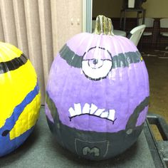 two painted pumpkins sitting next to each other