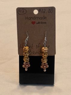 Natural painted wood trible beads. Tan color with darker tan stars, cream color with brown tone flower markings. Small spacers and made with stainless steel eye pins and sterling silver ear wires Artisan Brown Beaded Nickel-free Earrings, Adjustable Brown Beaded Earrings With Large Beads, Brown Dangle Earrings With Large Beads, Brown Wooden Beaded Earrings As Gift, Artisan Brown Earrings With Wooden Beads, Brown Wooden Beads Beaded Earrings As A Gift, Adjustable Brown Earrings With Wooden Beads, Brown Beaded Earrings With Wooden Beads For Gift, Gift Brown Beaded Earrings With Wooden Beads