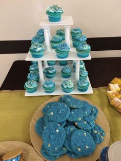 blue cupcakes and cookies on a table