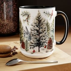 a coffee mug sitting on top of a wooden table next to a spoon and cup