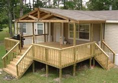 a small house with wooden steps leading to the front door and covered porch area,