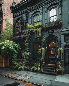 an old building with many plants growing on it's front and side windows, in the city