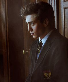 a man in a suit and tie leaning against a door