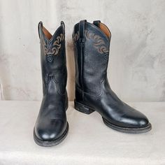 Very nice looking pair of bootscomfortable and practical. Ariat leather roper style round toe cowboy work boots. Black leather uppers and shafts with some very nice stitch work at the top of the boot. Brown leather linings and synthetic soles. Very nice condition. Some minor signs of previous wear but overall a great pair of boots with a lot of life left. Please made sure to view all the pics so you can get the best idea. Men's size 12 D (standard width) Western Round Toe Work Boots For Ranch, Western Work Boots With Round Toe For Ranch, Rugged Black Work Boots For Ranch, Western Moto Boots With Steel Toe, Western Style Rodeo Work Boots With Round Toe, Western Work Boots For Rodeo With Round Toe, Western Style Work Boots For Rodeo With Round Toe, Black Work Boots With Round Toe For Ranch, Western Style Rodeo Work Boots