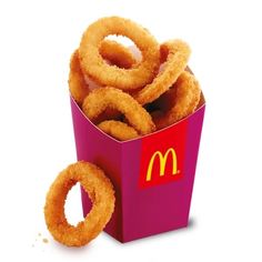 a pink box filled with onion rings on top of a white table next to a mcdonald's sign