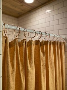 the curtain is hanging in front of the white brick wall and floor tiles on the walls