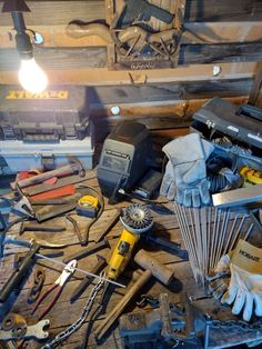 many tools are laying on the floor in front of some wood planks and other items