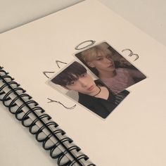 an open spiral notebook with two photos on it