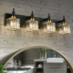 a bathroom vanity light with three lights on the wall and a mirror in front of it