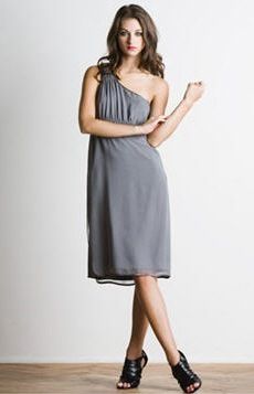 a woman in a gray dress posing for the camera