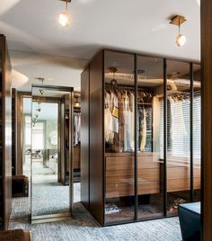 a walk in closet with mirrored doors and clothes hanging on hangers next to it