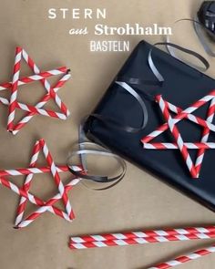 some red and white striped straws are next to a black box with scissors on it