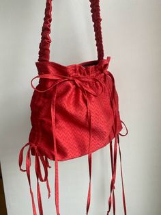 a red handbag hanging on a white wall