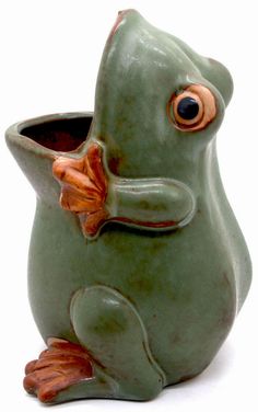 a green ceramic frog planter with an orange nose