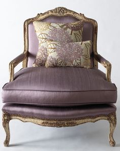 a purple chair with pillows on top of it