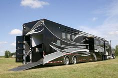 a black trailer parked on top of a grass covered field