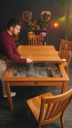 a man sitting at a wooden table with a board game in front of him on top of it